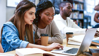 Students looking at a laptop.