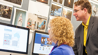 A photo of two people using a computer.