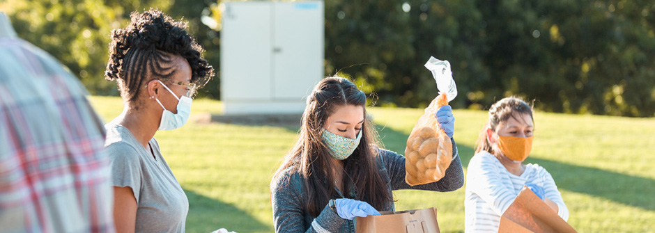 A photo of a group of people handing out food.