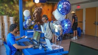 Student receiving laptop during their Pirate Adventure orientation.