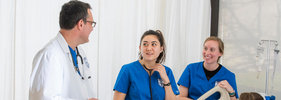 Nursing students working with a doctor.