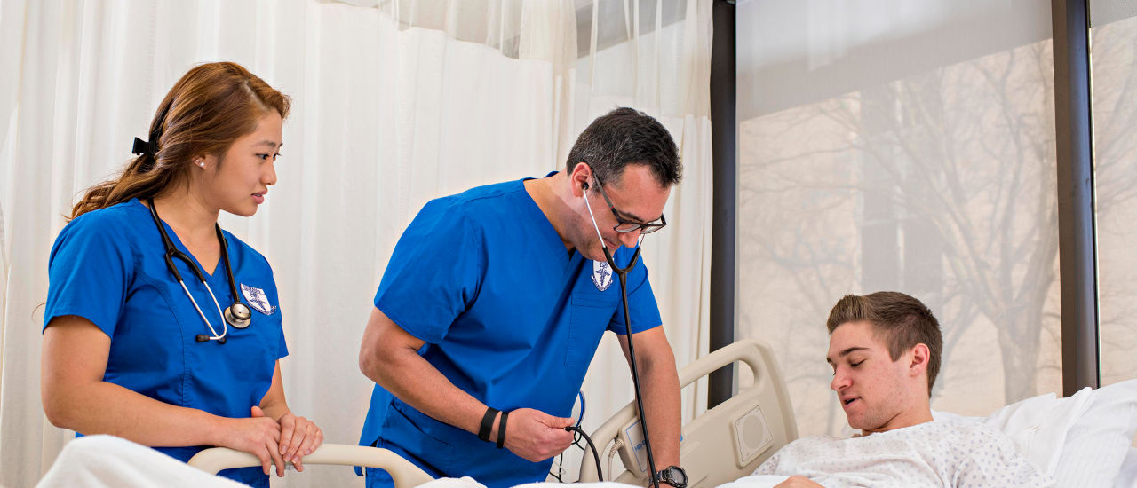 Nursing students working with a patient 