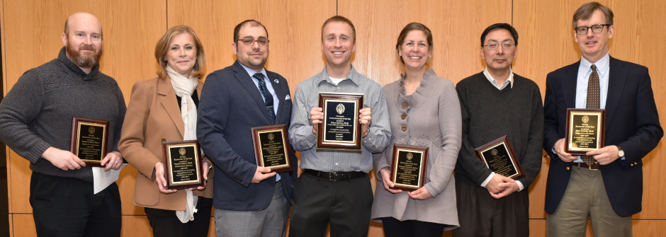 A photo of a group of faculty holding award plaques.