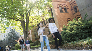 Students talking on the campus Green in the Fall.