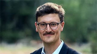 David I. Backer, Ph.D., critically examines the financial structures of U.S. public schools and advocates for policies that strives for equitable education for all.