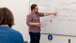 Applied Physics professor pointing to whiteboard