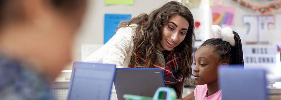 An educator with a student in a classroom.