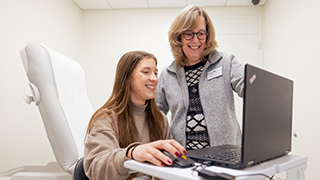 Student and health practitioner in front of a laptop