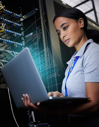 A female IT professional working in a server room.