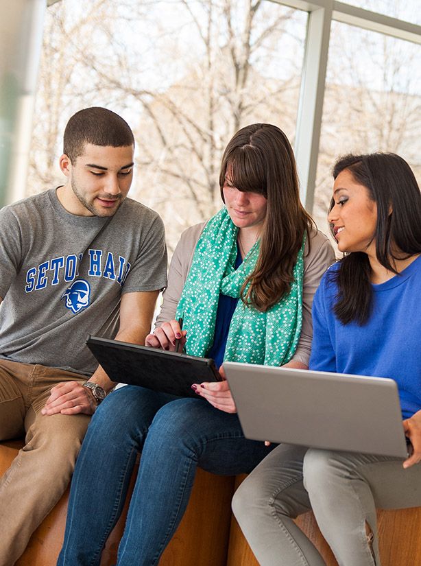 three students at a tablet