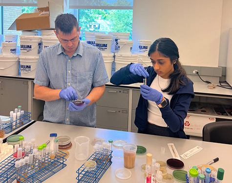 Erik Hill and Aasha Patel working in a chemistry lab. 