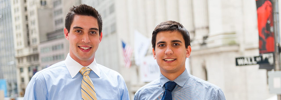 Student in front of Wall Street sign. 