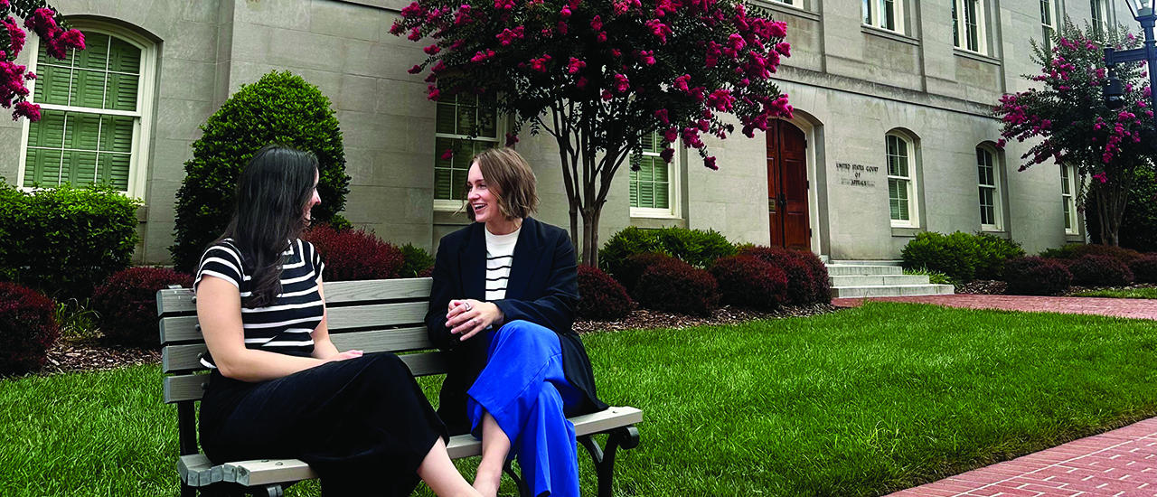 Kaylyn Sanbower, ‘15 talking with a friend on a bench.
