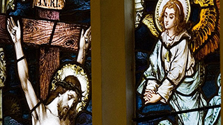 Stained glass window of Christ on the cross and an angel visiting his side