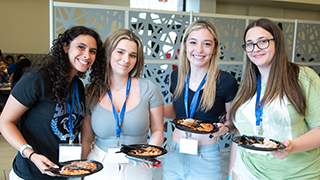 Image of four students each holding a plate in the University Center.