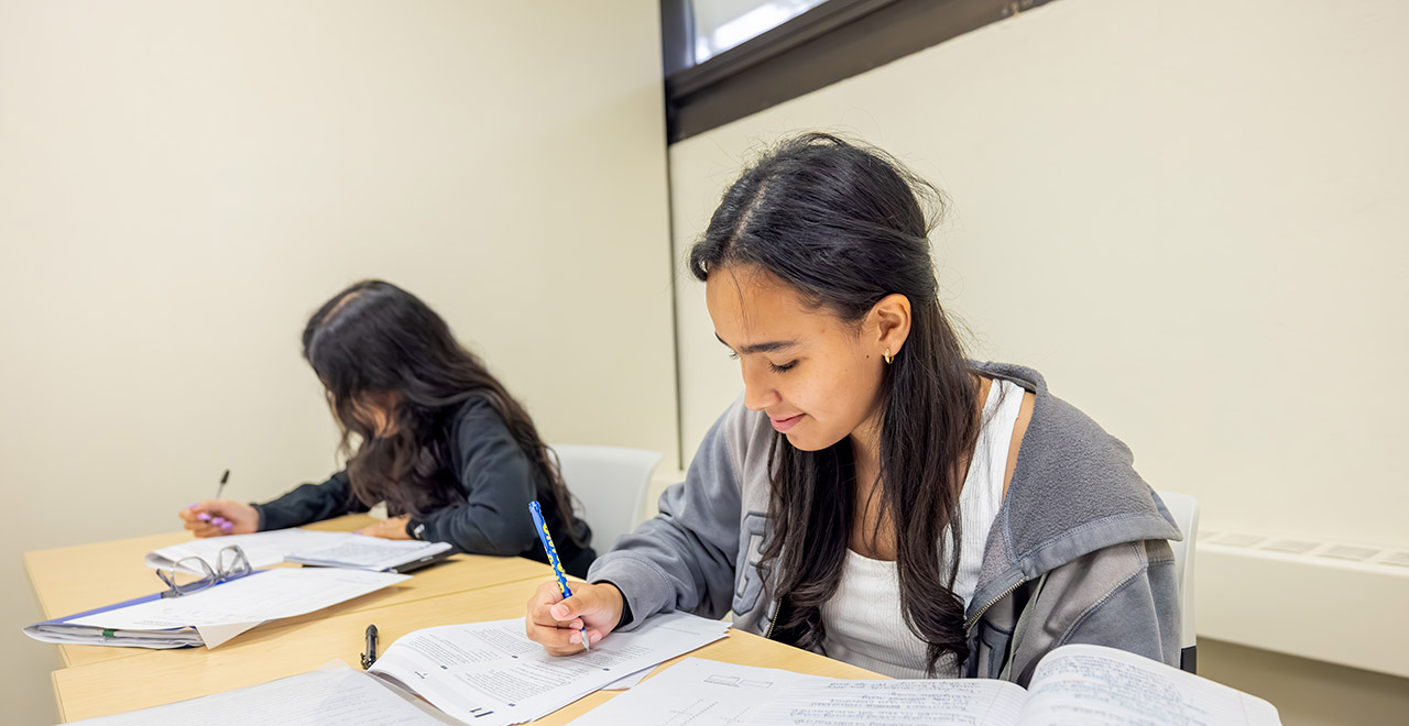 A student taking notes in a classroom