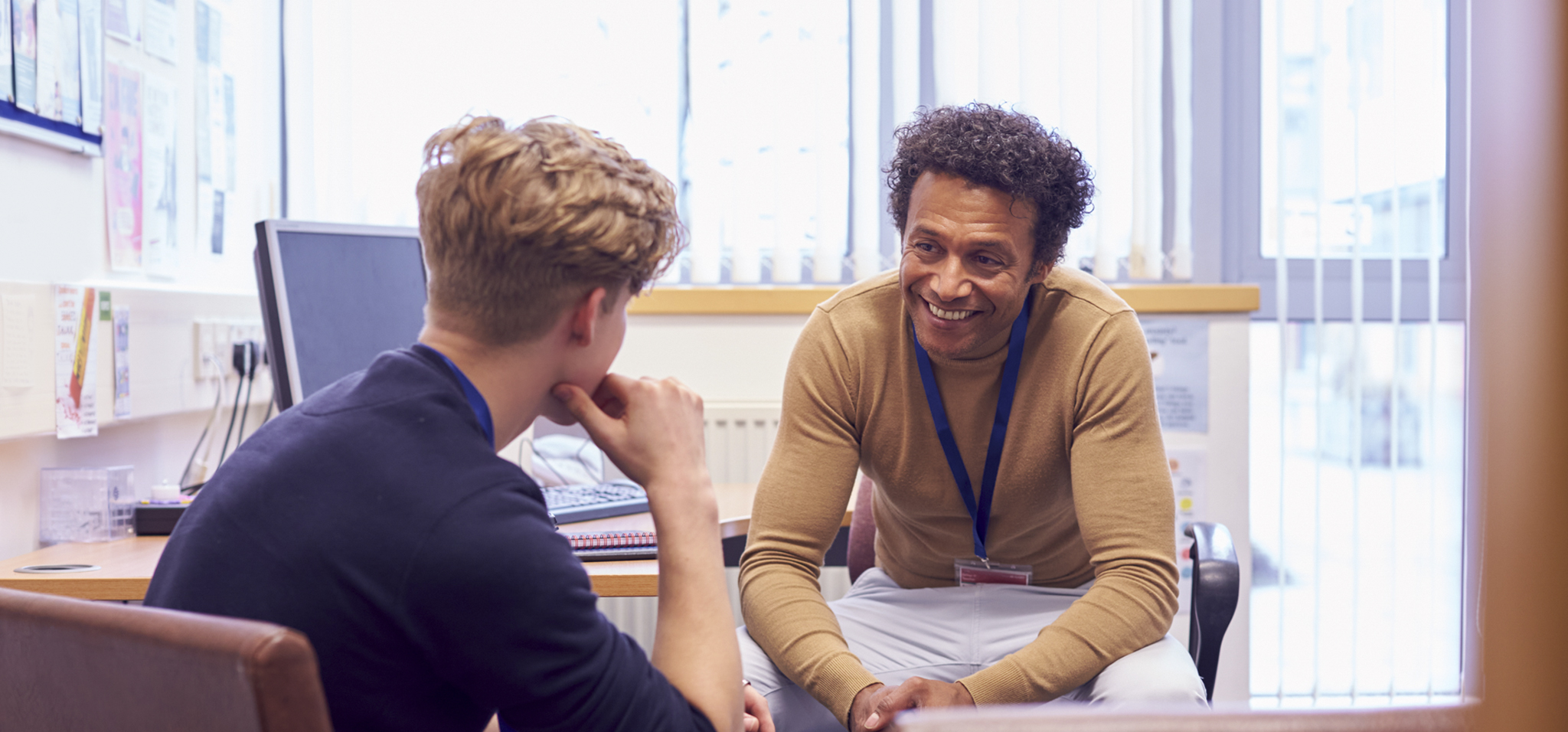 Image of faculty member talking to a student in their office 