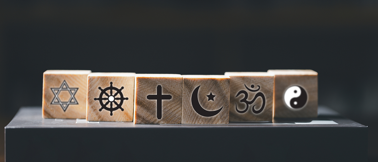 A row of wooden blocks, each with a symbol from a different world religion.